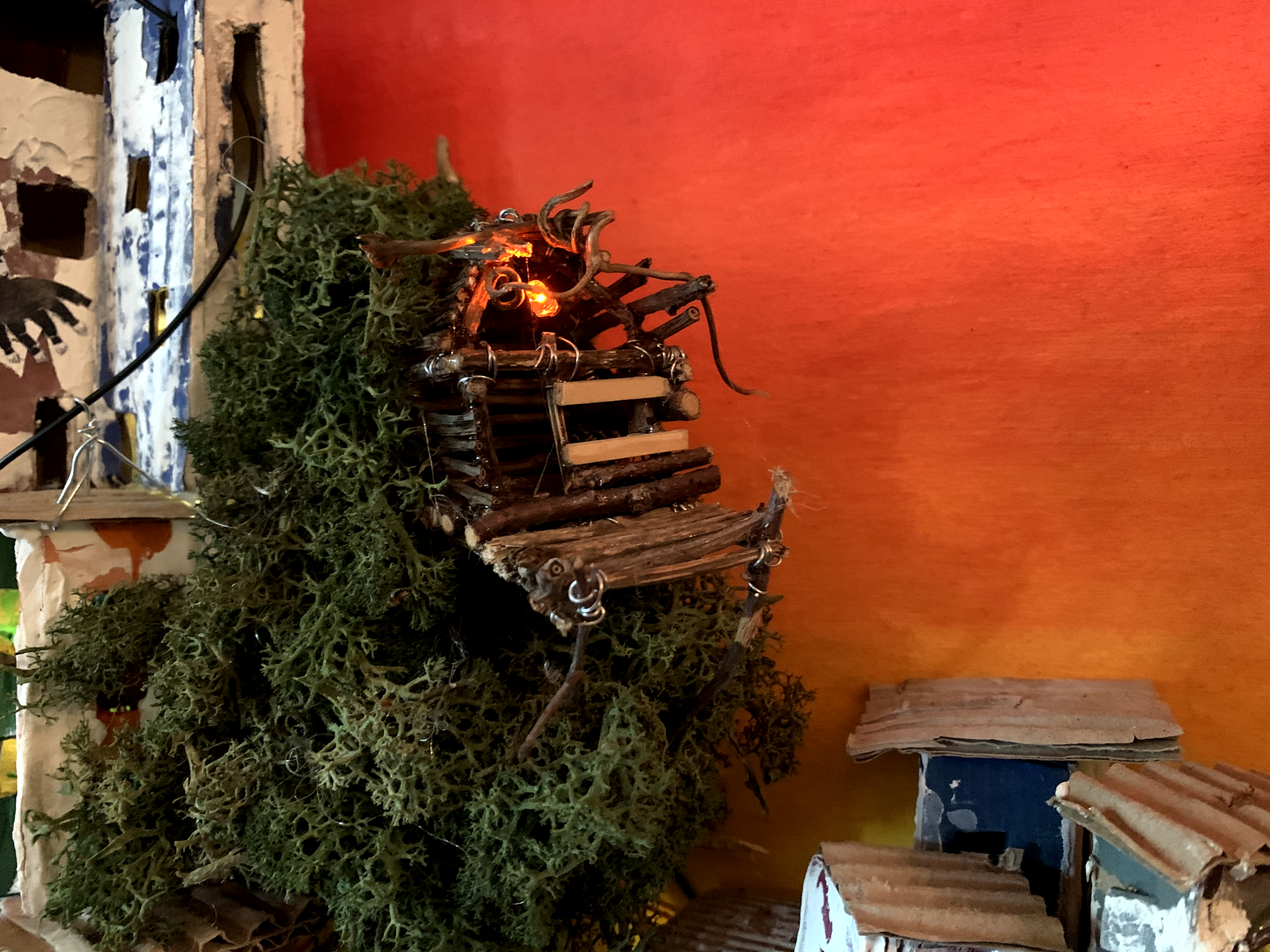 Illuminated treehouse growing from the miniature city