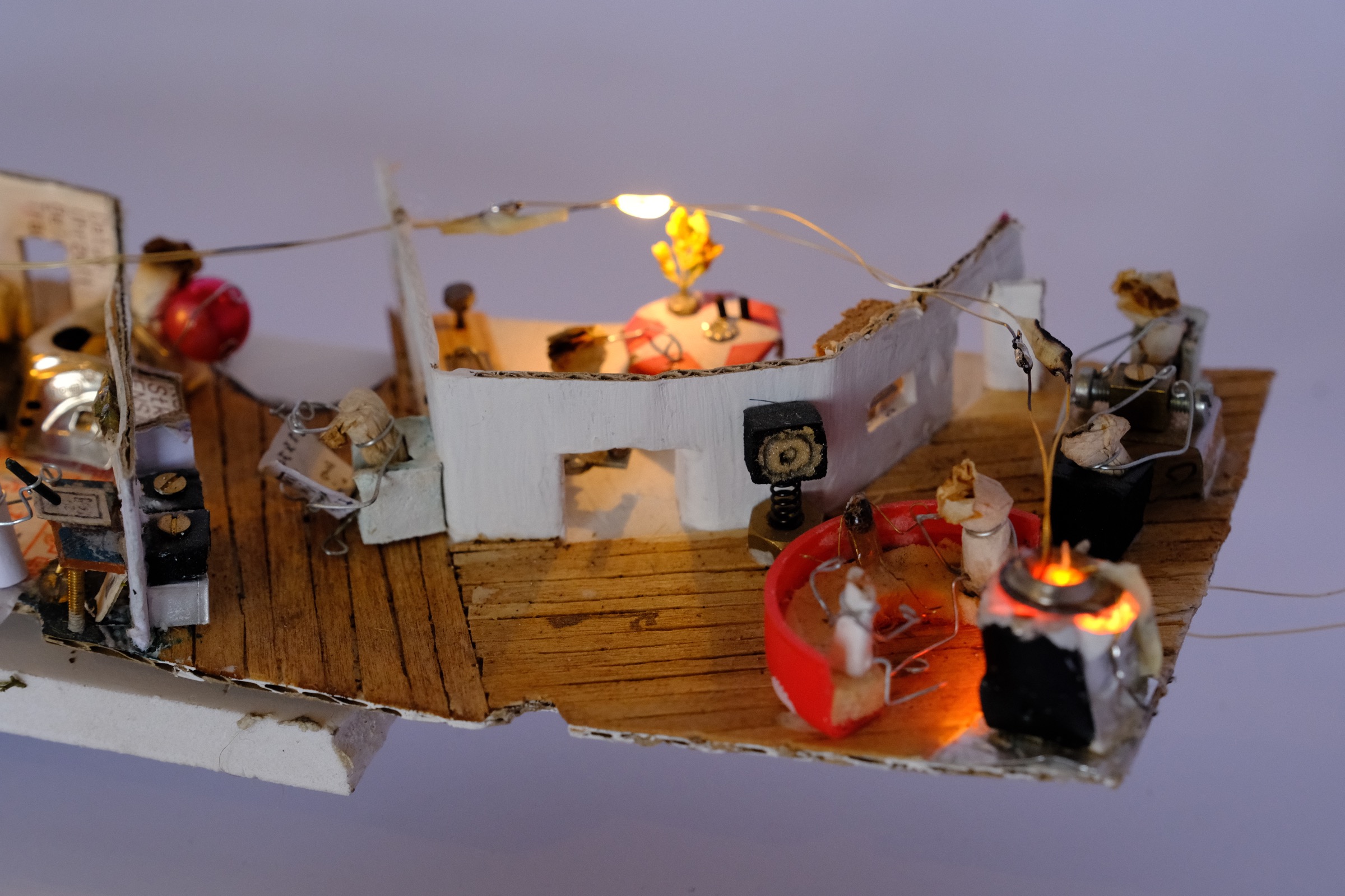 Cigarette figures gathered at a fireplace and playing a table game
